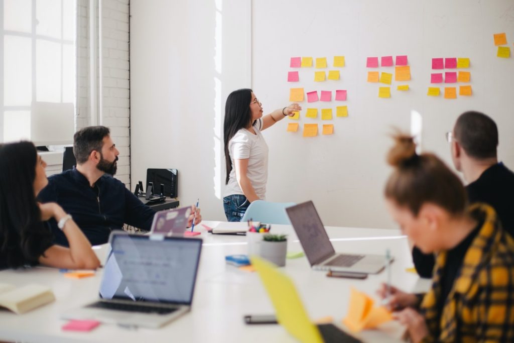 woman explaining best practices on post it notes in a meeting