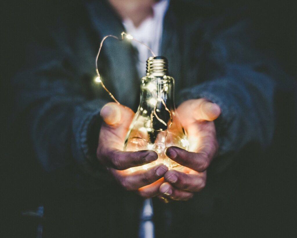 Uomo che tiene la lampadina in entrambe le mani