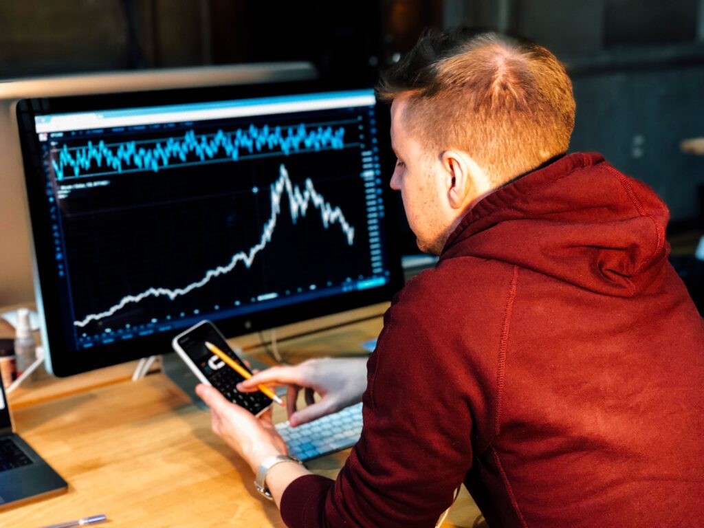 Ragazzo con uno smartphone e un pc con grafico