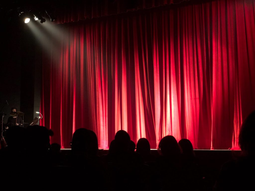 audience in front of theater red curtain 