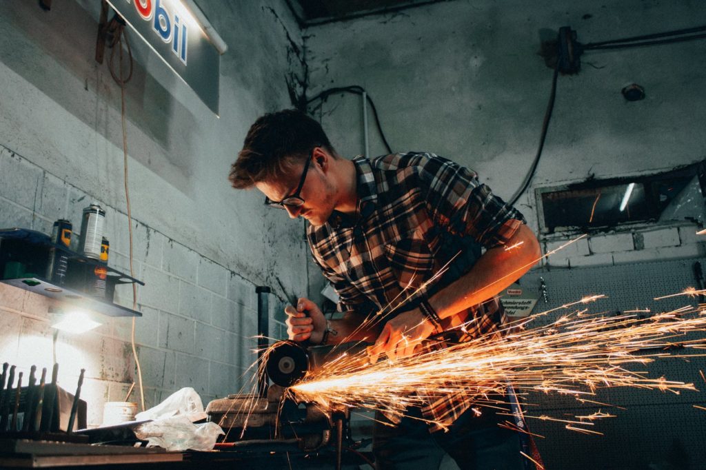 man grinding metal with sparks flying