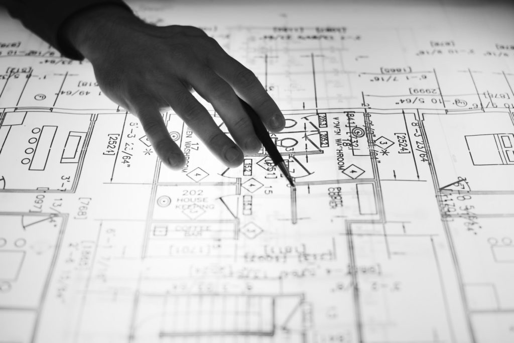 black and white photo of someone working on a blueprint