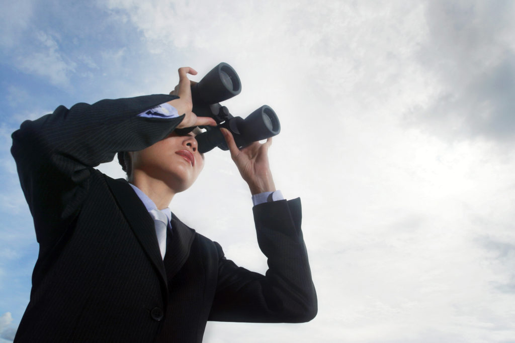 man looking through binoculars 