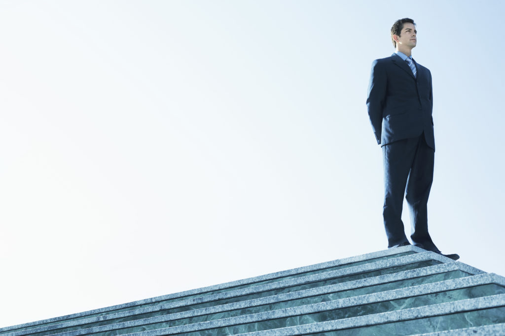 man in business suit standing on platform