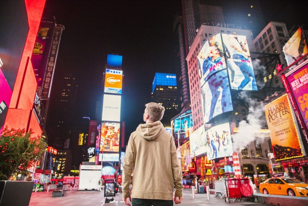 boy standing in timesquare at night