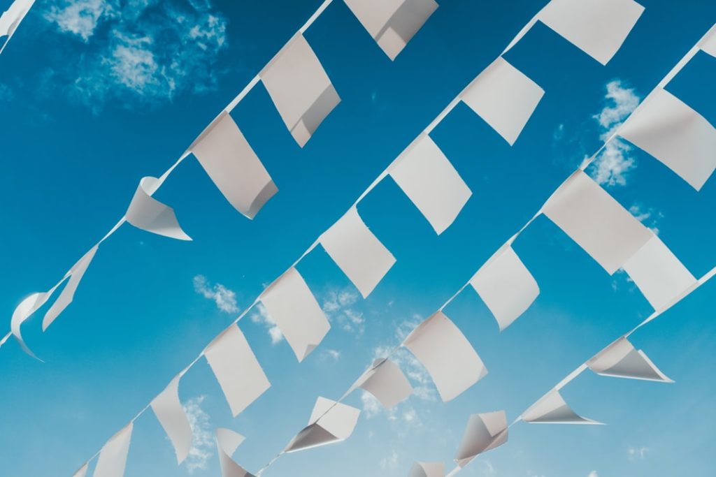 white flags against blue sky