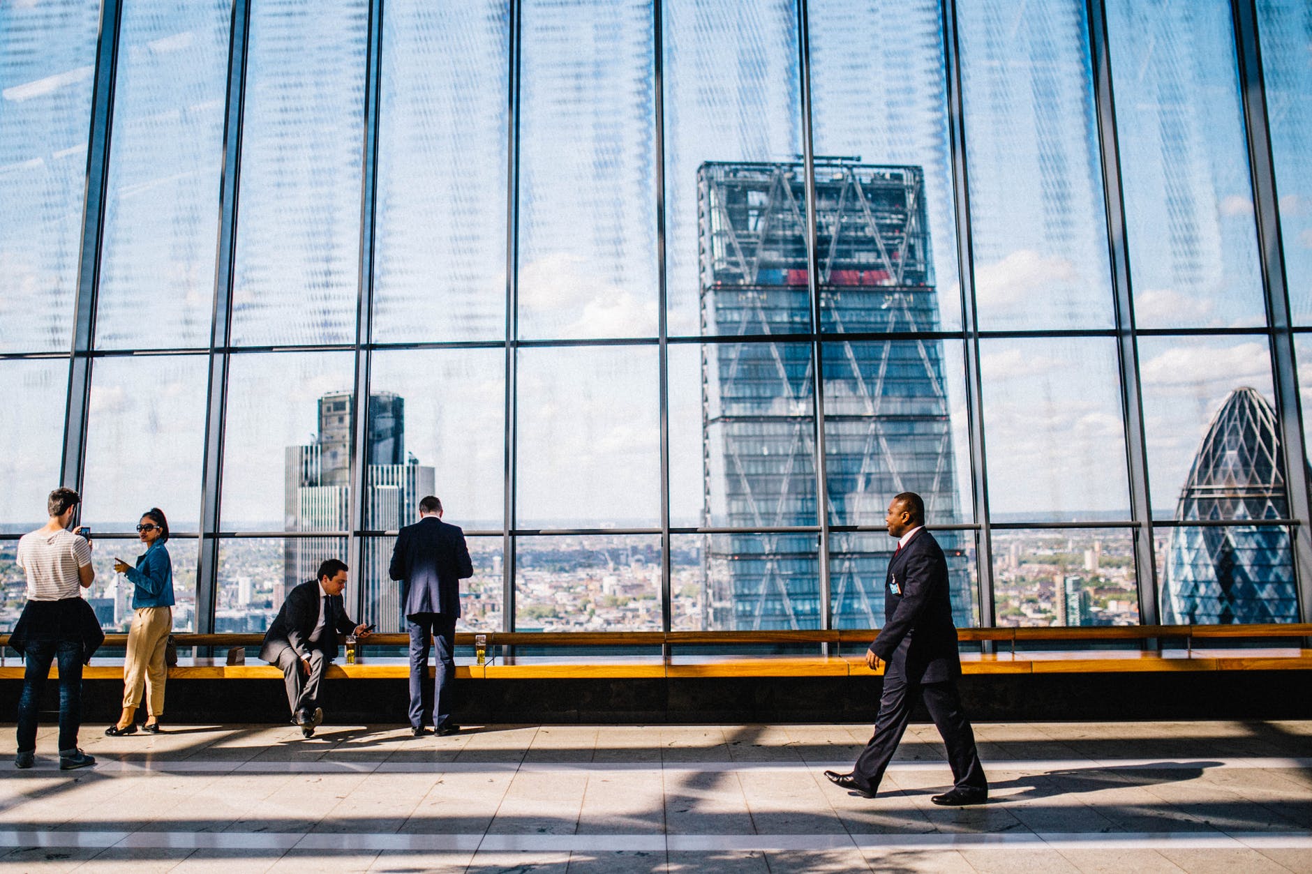 man walking in a  suit with a city scape behind him 