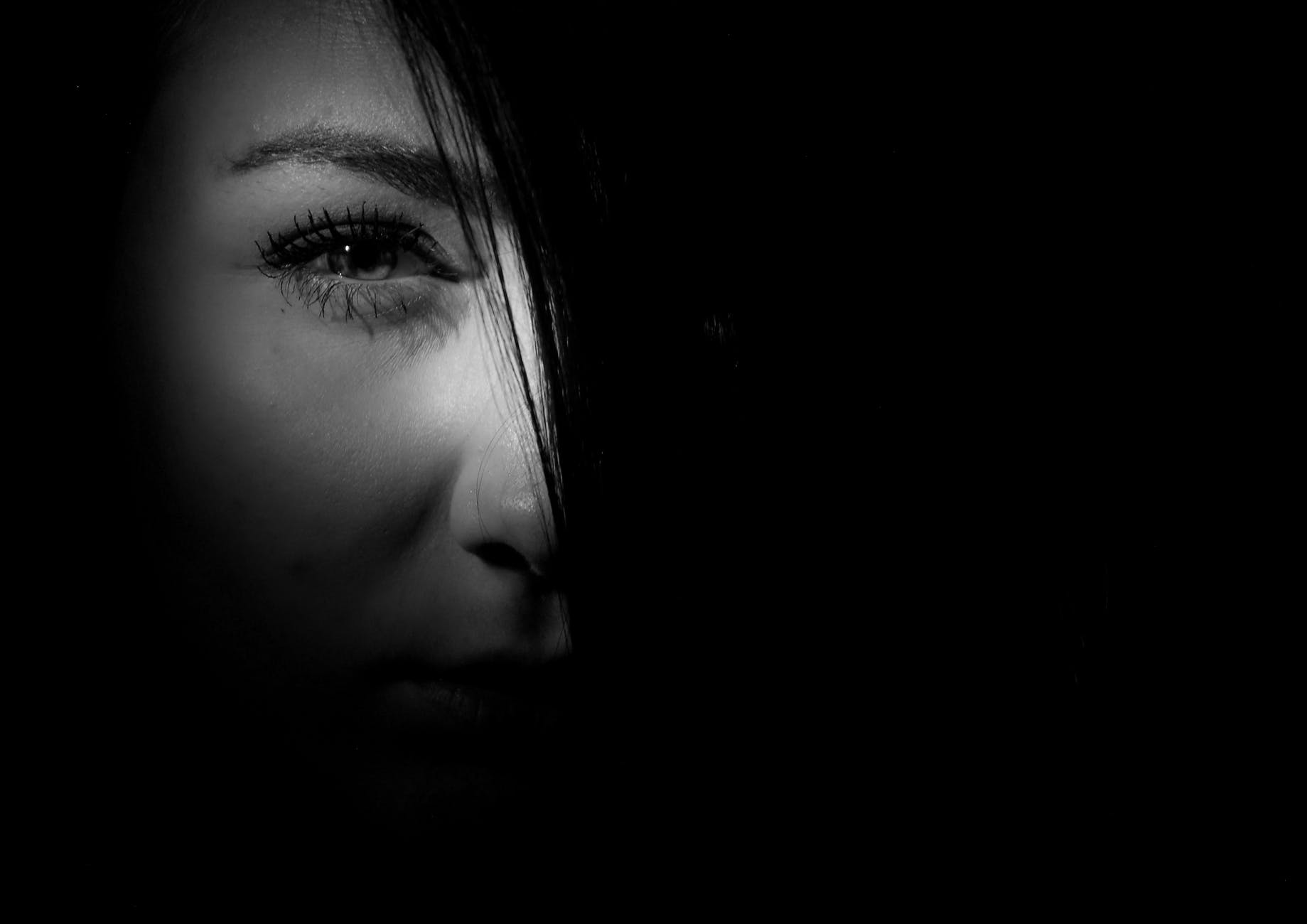 black and white photo of a woman with half her face lit up 