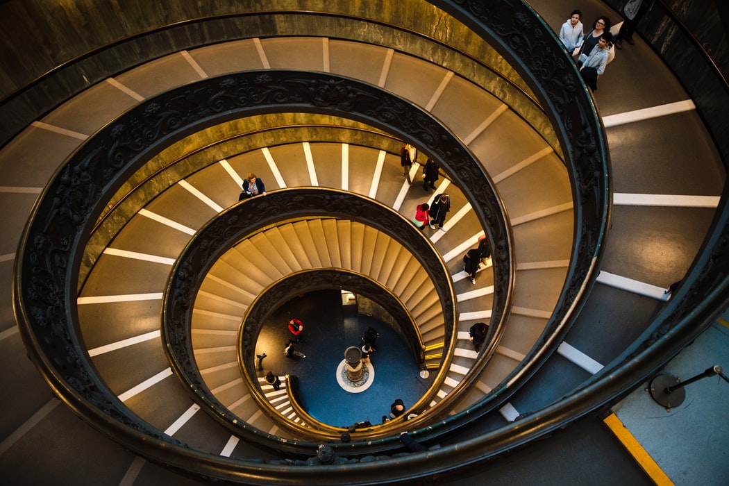 staircase winding down with people on it 