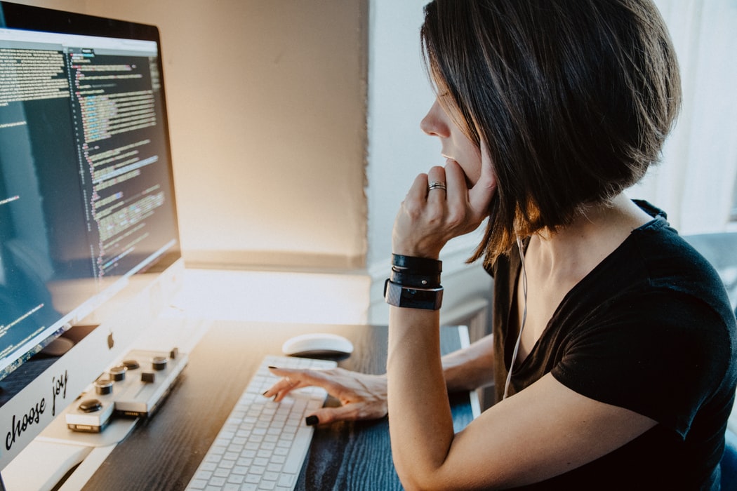 a woman web developer sitting at her desk while coding