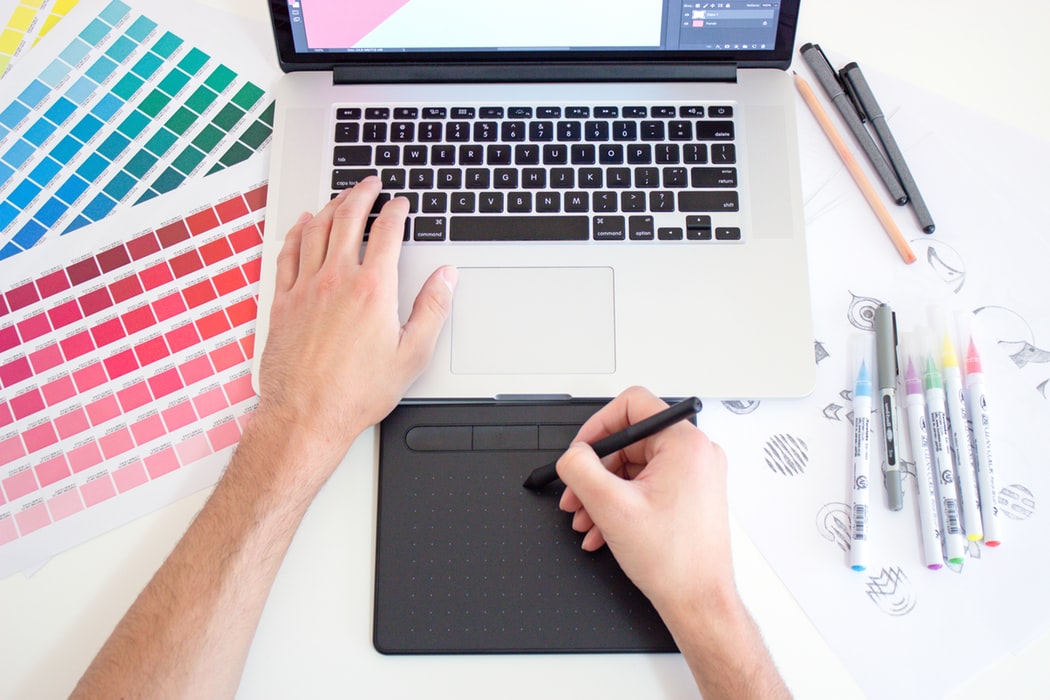 web designer with color palettes and computer in front of him 