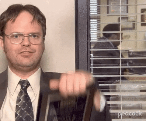 Dwight Schrute sosteniendo dos placas de premios para empleados