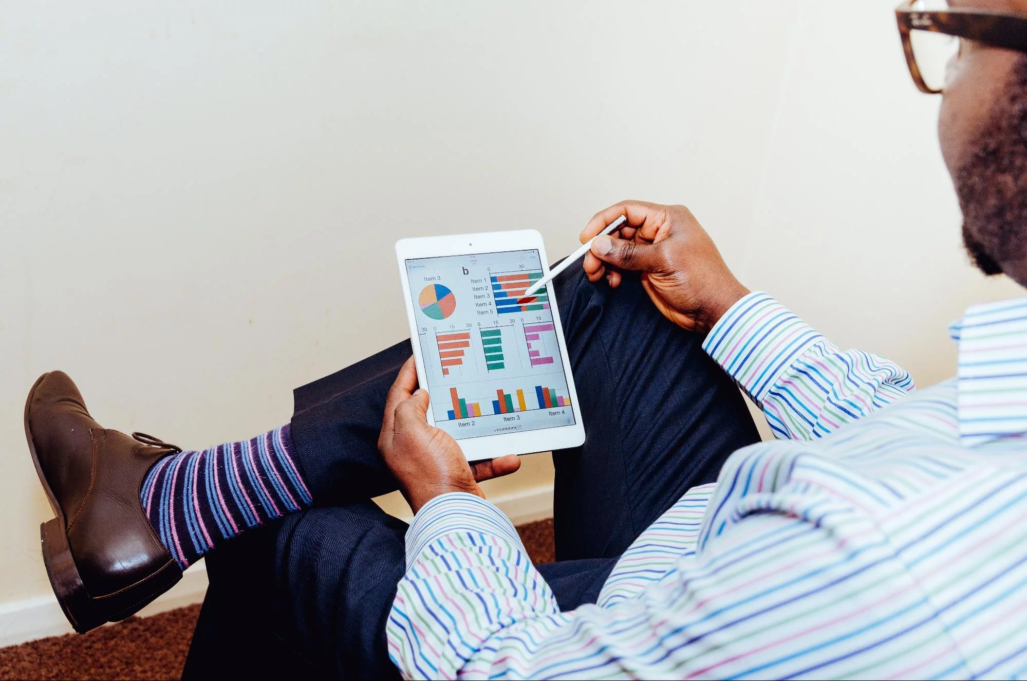 Ein schwarzer Mann mit einem Tablet und Blick auf Diagramme und Grafiken