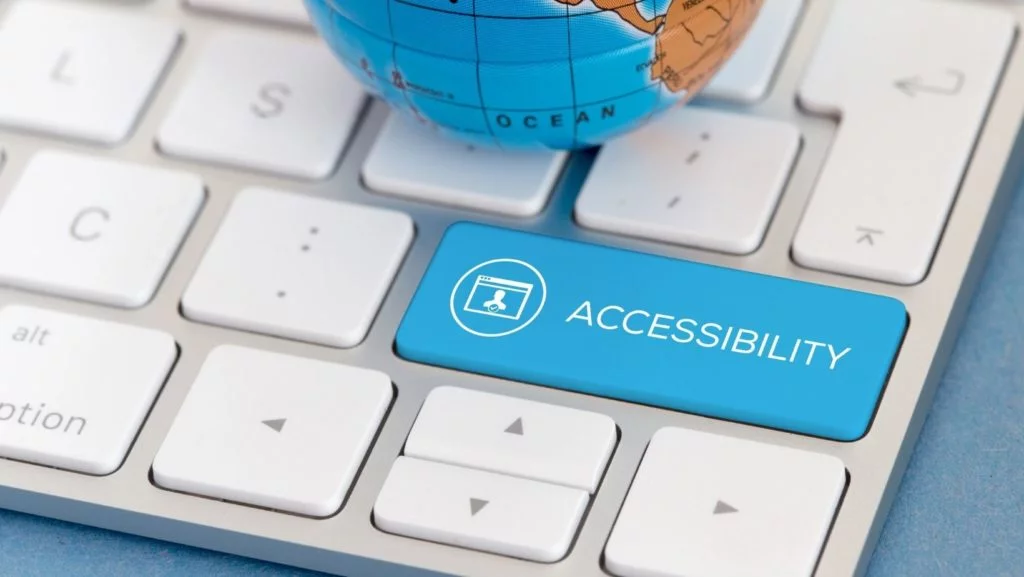 Una tastiera con un pulsante blu che dice accessibilità invece di entrare con un mini mappamondo in alto