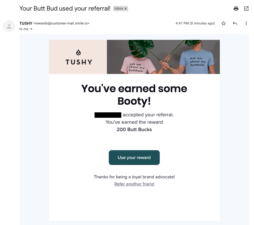 أسماء نقاط المكافآت الإبداعية - لقطة شاشة لإحدى رسائل البريد الإلكتروني لبرنامج الإحالة من Tushy. يُظهر شعار البريد الإلكتروني شعارهم ، مع شخصين يرتديان قمصانًا وردية وزرقاء تقول: "اسألني عن فتحة مؤخرتي". تقول نسخة البريد الإلكتروني ، "لقد ربحت بعض الغنيمة! قبل NAME إحالتك. لقد ربحت مكافأة 200 باكز. استخدم مكافأتك. شكرا لكونك من المدافعين المخلصين عن العلامة التجارية! إحالة صديق آخر ".