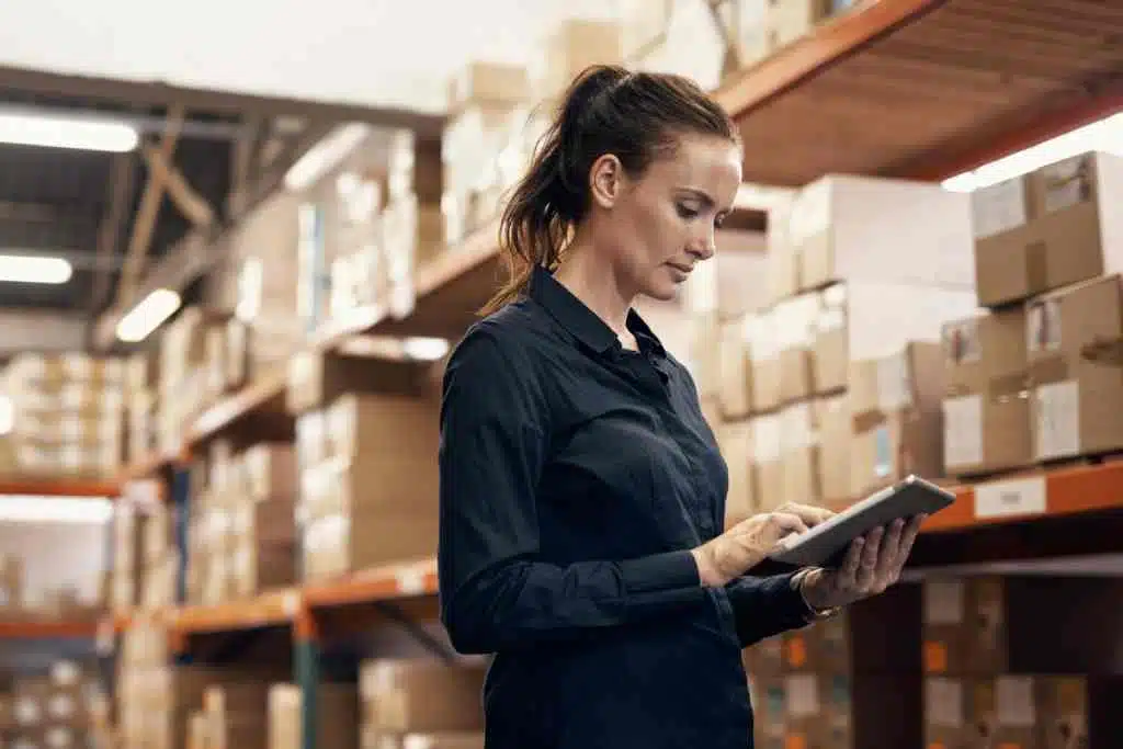 una mujer rastreando el inventario en un almacén