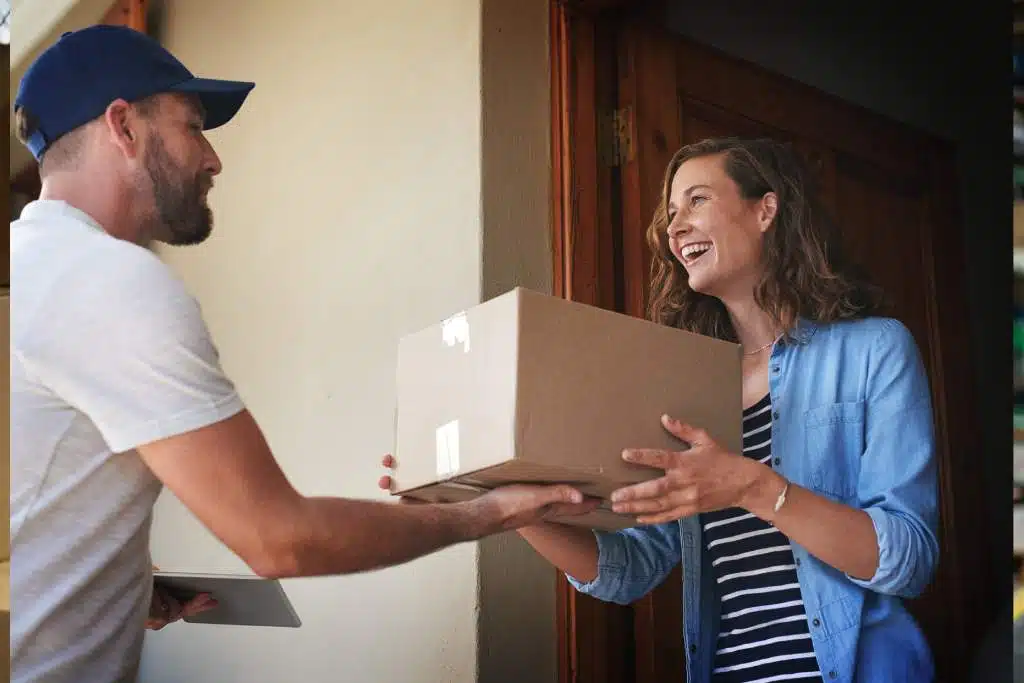 Homem de entrega que entrega o pacote da mulher