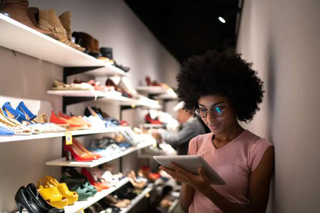 Femme vérifiant l'inventaire dans un magasin de chaussures