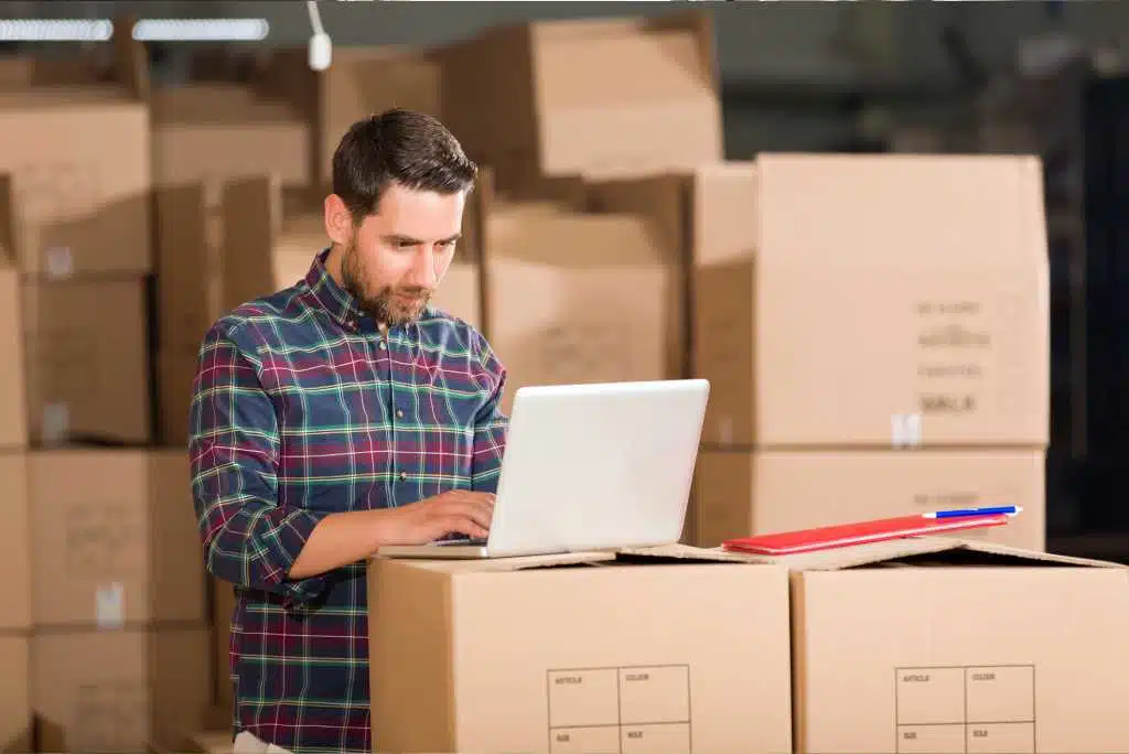 Homme d'affaires utilisant le système de gestion des stocks du magasin dans l'entrepôt