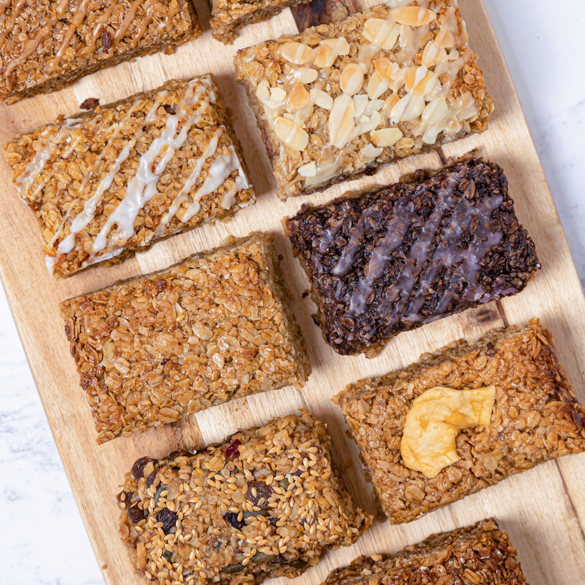 Image vue d’ensemble de 8 flapjacks à base d’avoine sur une planche à découper en bois.