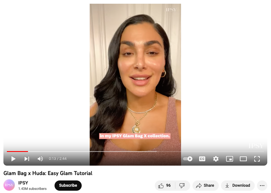 Un'immagine tratta da un video di YouTube mostra l'influencer di bellezza Huda Kattan che sta per iniziare un tutorial sul trucco con gli elementi di trucco della sua Glam Bag creata da IPSY come parte della strategia di partnership con l'influencer del marchio di bellezza.