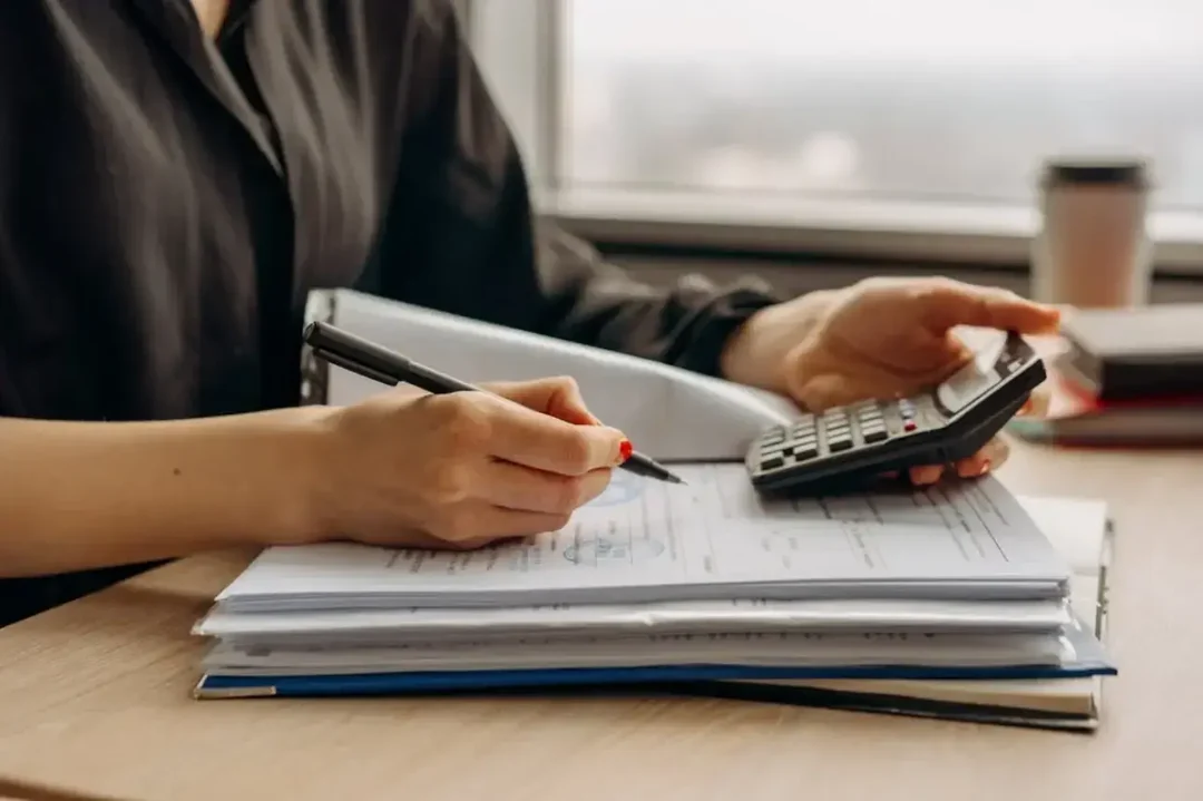 personne-avec-calculatrice-et-documents