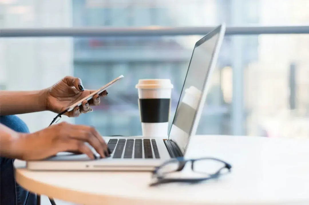 persona-che-utilizza-smartphone-e-macbook