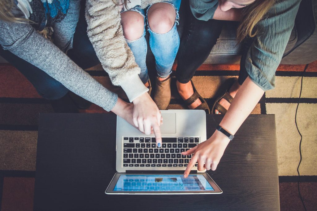 Persone che puntano allo schermo del laptop