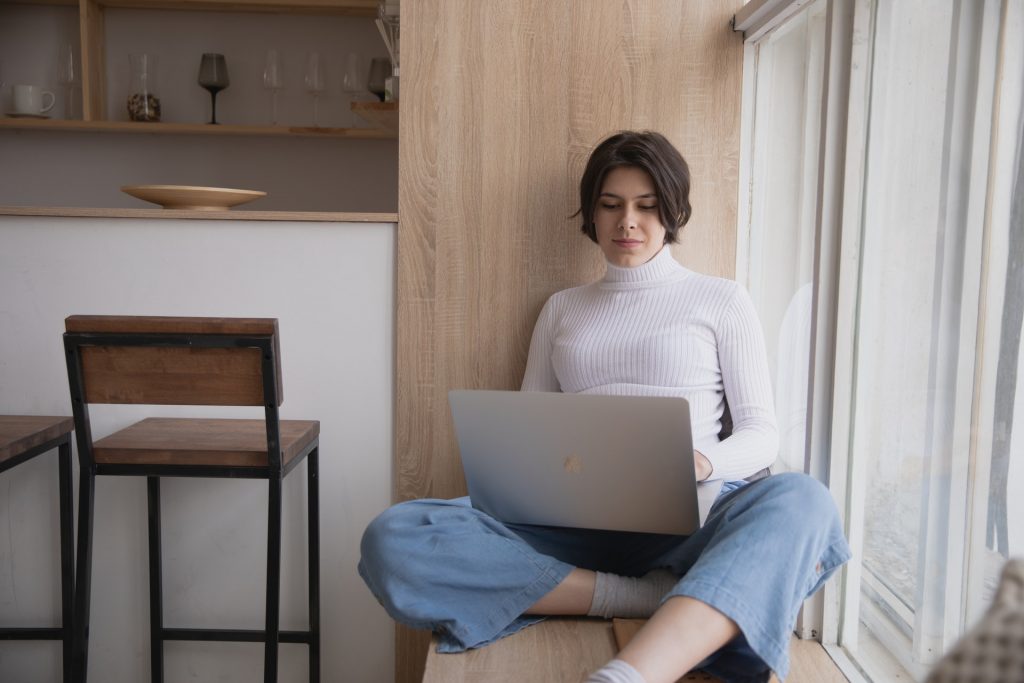 Mujer leyendo desde la computadora portátil