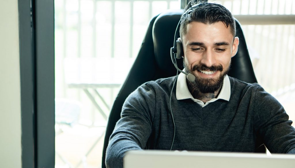 Homem de suéter preto usando fones de ouvido pretos