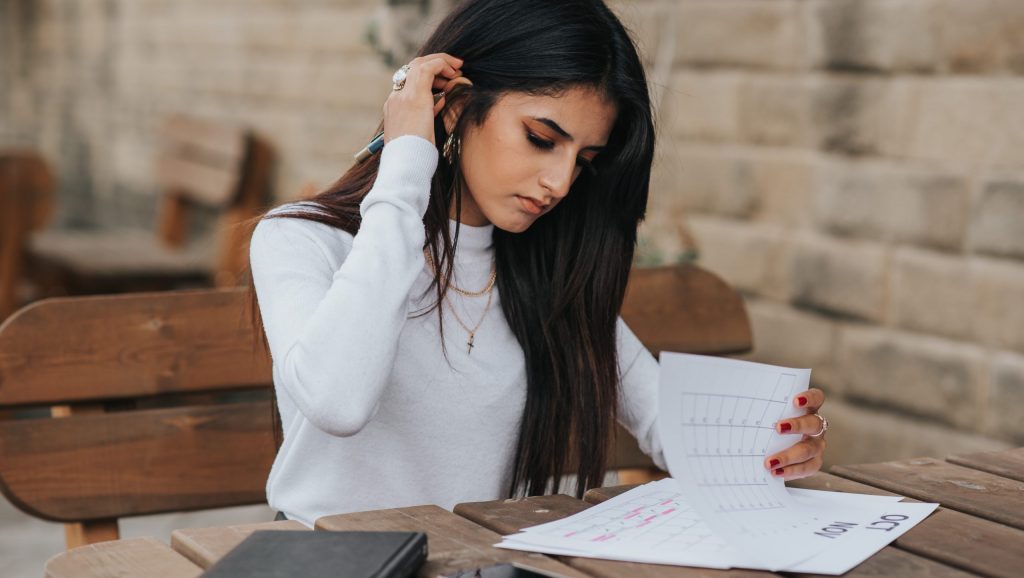 Mujer joven étnica leyendo notas