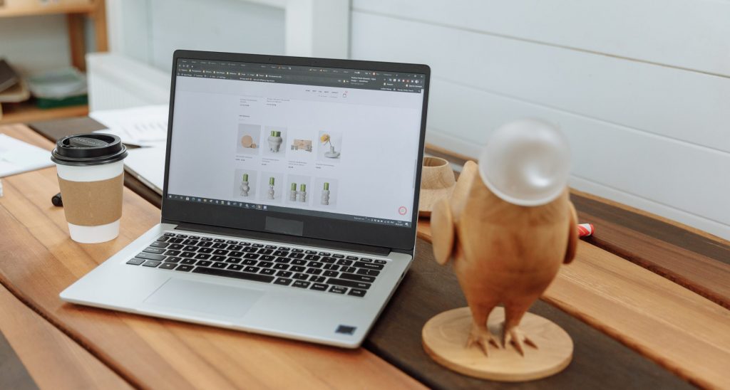 Laptop en una mesa de madera con el sitio web de negocios de diseño en la pantalla