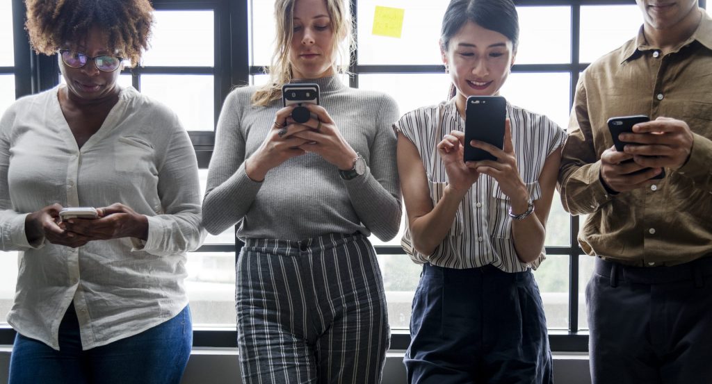 Gruppe verschiedener Menschen, die Smartphones verwenden