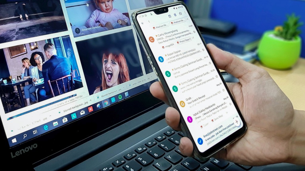 orang yang menggunakan smartphone dan komputer laptop