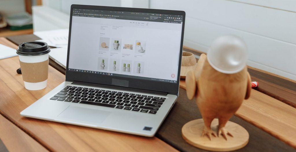 Laptop en una mesa de madera con el sitio web de negocios de diseño en la pantalla