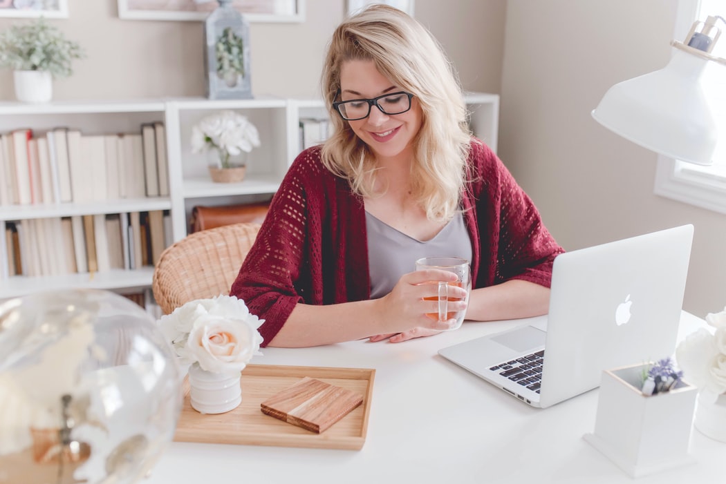 a woman smiling to a laptop