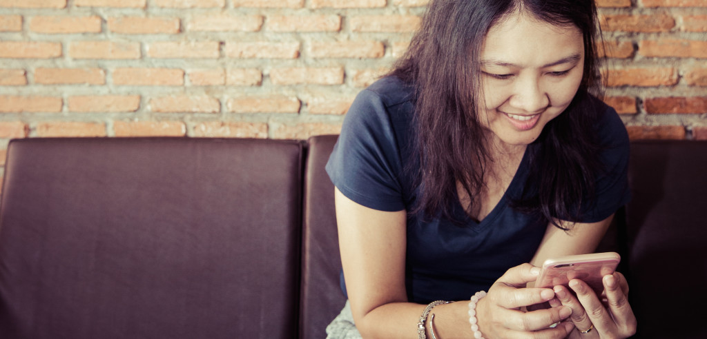 Mujer sonriente en teléfono inteligente