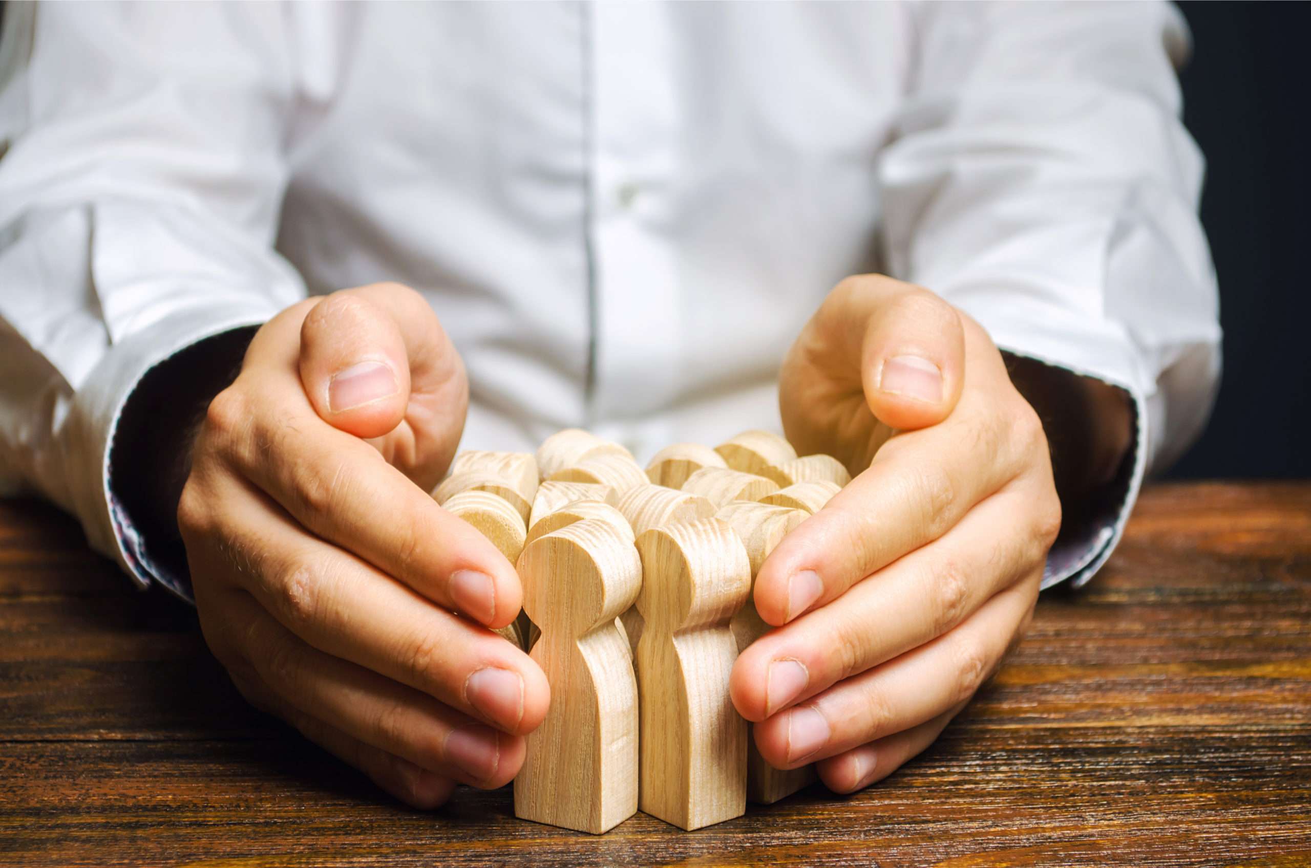 manos sosteniendo figuras de madera